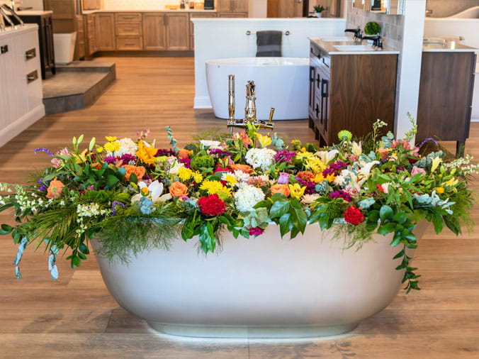 Free standing bath tub with flowers in it at the Weinstein Willow Grove Kitchen & Bath Showroom